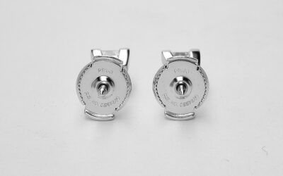 A pair of single stone princess cut diamond ear studs mounted in platinum with 'Guardian' comfort fit fittings.