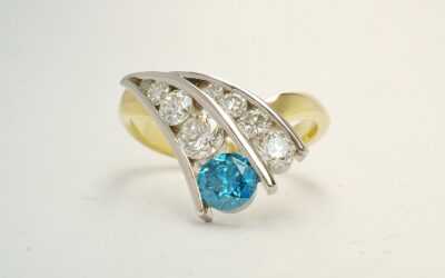 A 9 stone HTHP treated sky blue round brilliant cut diamond and white round brilliant cut diamond ring mounted in 18ct. yellow gold and platinum.