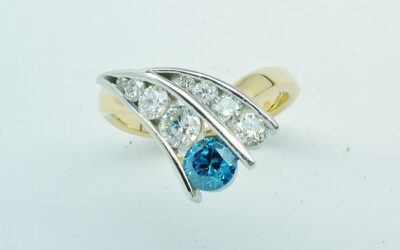 A 9 stone HTHP treated sky blue round brilliant cut diamond and white round brilliant cut diamond ring mounted in 18ct. yellow gold and platinum.