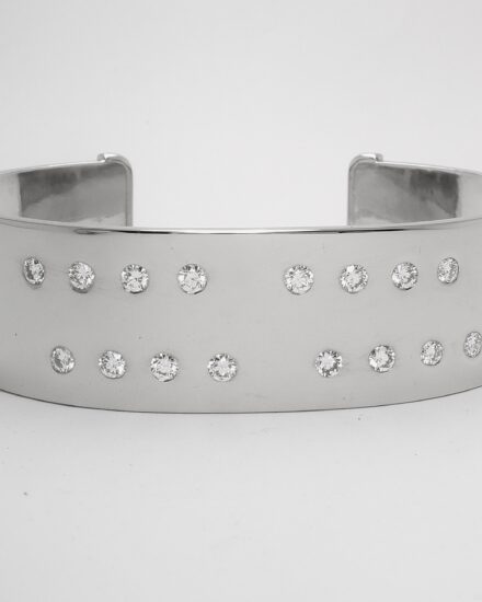 A 20mm broad heavy sectioned platinum torque bangle flush set with 16 round brilliant cut diamonds.