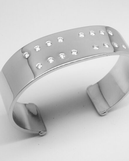 A 20mm broad heavy sectioned platinum torque bangle flush set with 16 round brilliant cut diamonds.