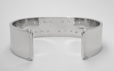 A 20mm broad heavy sectioned platinum torque bangle flush set with 16 round brilliant cut diamonds.