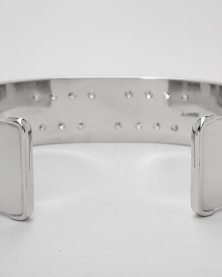 A 20mm broad heavy sectioned platinum torque bangle flush set with 16 round brilliant cut diamonds.