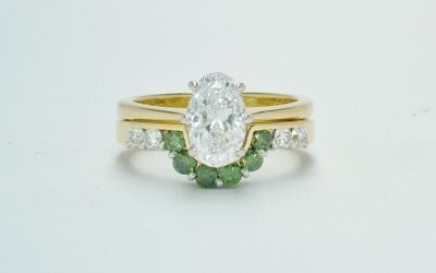 A 10 stone part channel set round brilliant cut green and white diamond wedding ring shaped to fit around a single stone oval diamond engagement ring.
