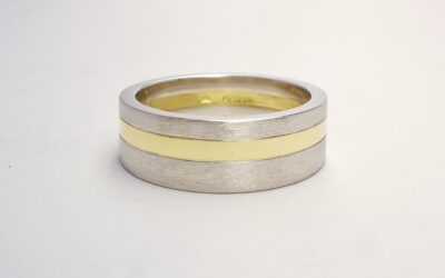 A 6mm broad heavy flat sectioned platinum and 18ct. yellow gold gents wedding ring.