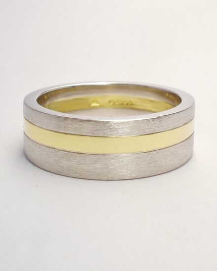 A 6mm broad heavy flat sectioned platinum and 18ct. yellow gold gents wedding ring.
