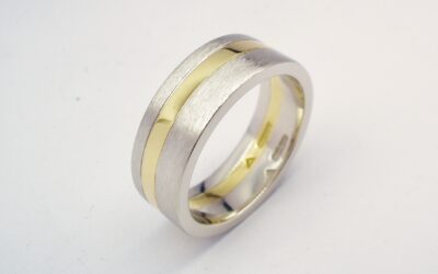A 6mm broad heavy flat sectioned platinum and 18ct. yellow gold gents wedding ring.