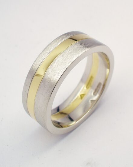 A 6mm broad heavy flat sectioned platinum and 18ct. yellow gold gents wedding ring.