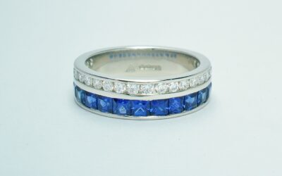 A 37 stone square cut sapphire and round brilliant cut diamond ring channel set in a 5mm broad flat heavy sectioned platinum band.