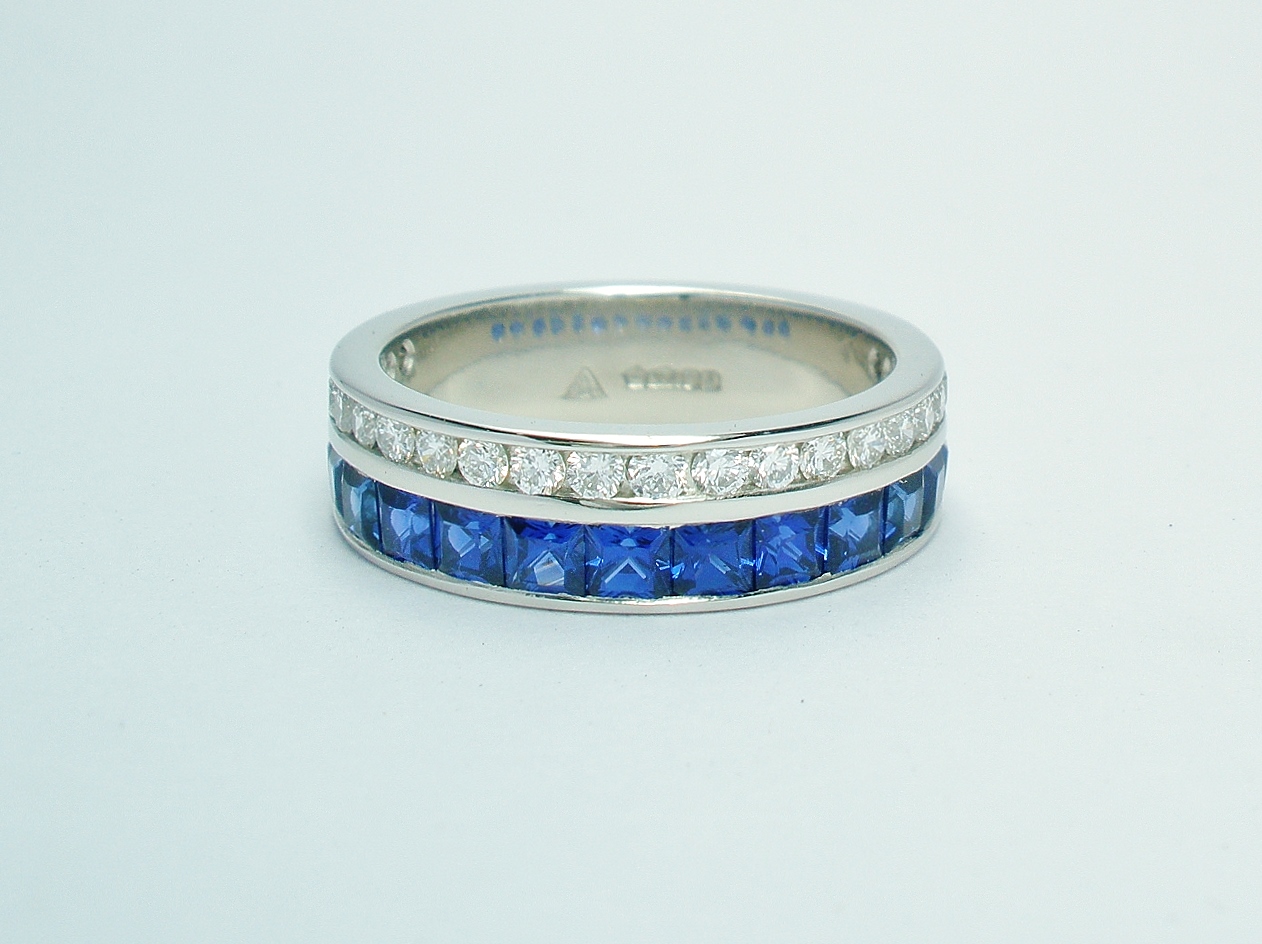 A 37 stone square cut sapphire and round brilliant cut diamond ring channel set in a 5mm broad flat heavy sectioned platinum band.