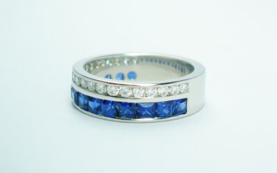 A 37 stone square cut sapphire and round brilliant cut diamond ring channel set in a 5mm broad flat heavy sectioned platinum band.