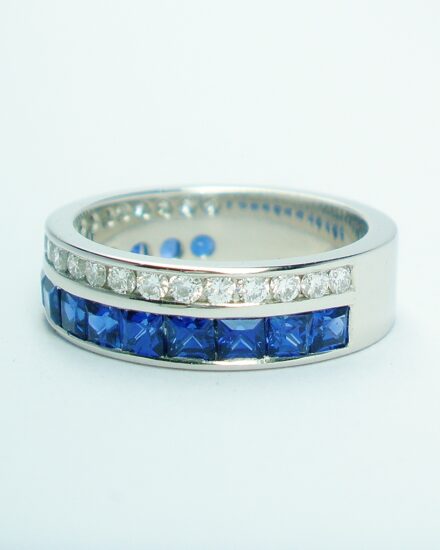 A 37 stone square cut sapphire and round brilliant cut diamond ring channel set in a 5mm broad flat heavy sectioned platinum band.