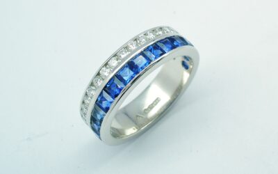 A 37 stone square cut sapphire and round brilliant cut diamond ring channel set in a 5mm broad flat heavy sectioned platinum band.