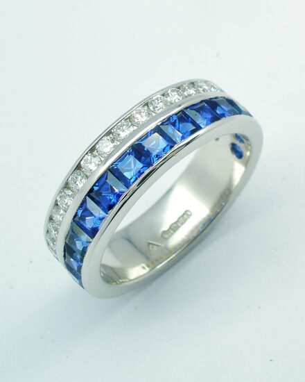 A 37 stone square cut sapphire and round brilliant cut diamond ring channel set in a 5mm broad flat heavy sectioned platinum band.