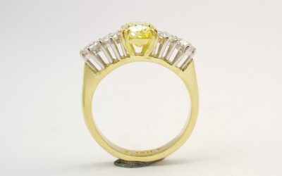 A 5 stone HTHP treated canary yellow cushion shaped diamond and round brilliant cut diamond ring mounted in 18ct yellow gold and platinum.