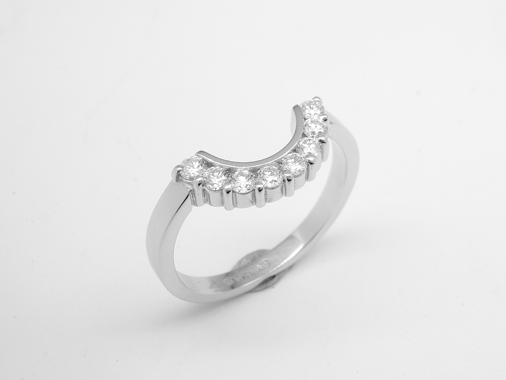 An 8 stone part channel set round brilliant cut diamond ring mounted in platinum and shaped to fir around a 13 stone round diamond cluster ring.