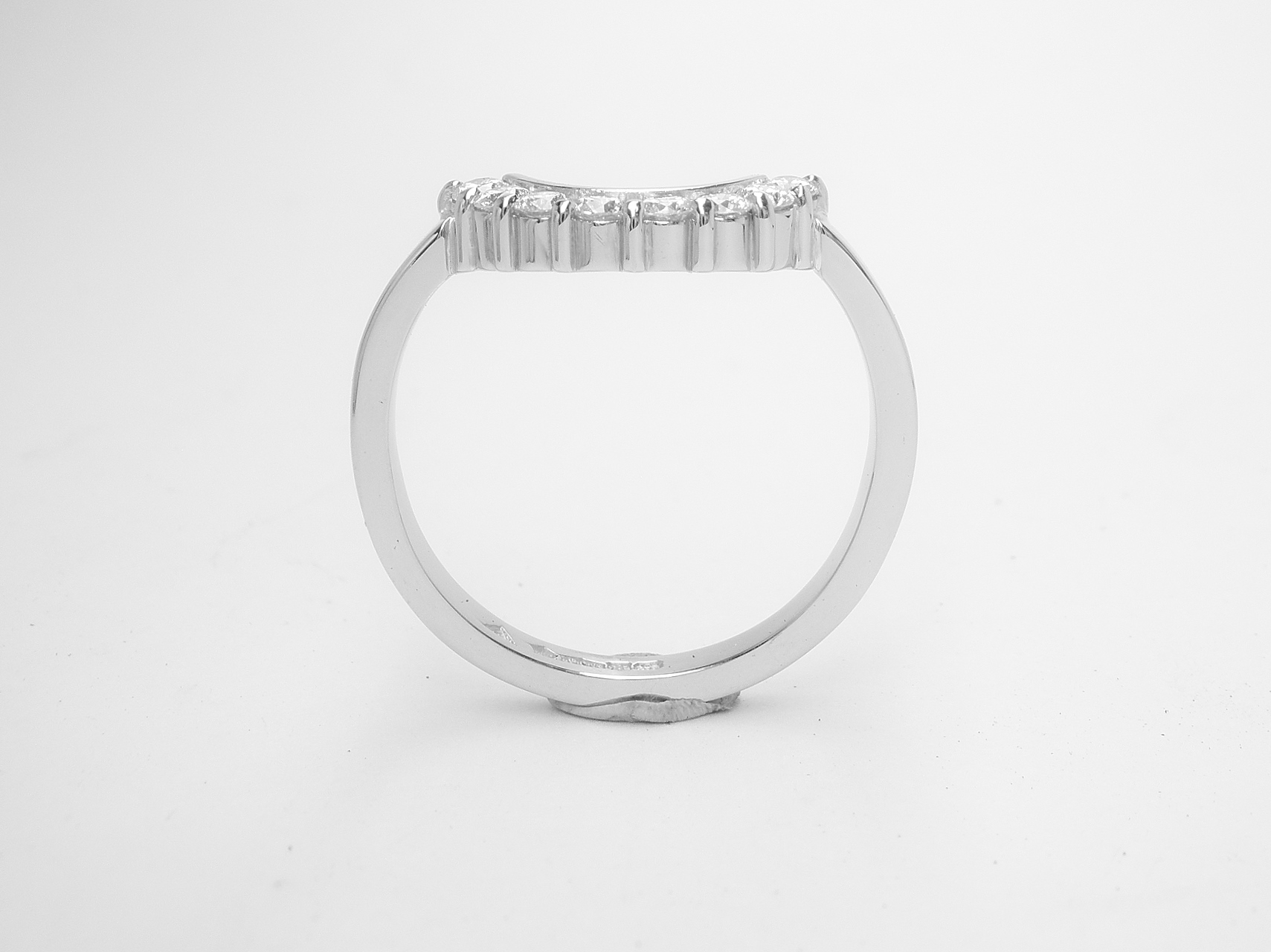 An 8 stone part channel set round brilliant cut diamond ring mounted in platinum and shaped to fir around a 13 stone round diamond cluster ring.