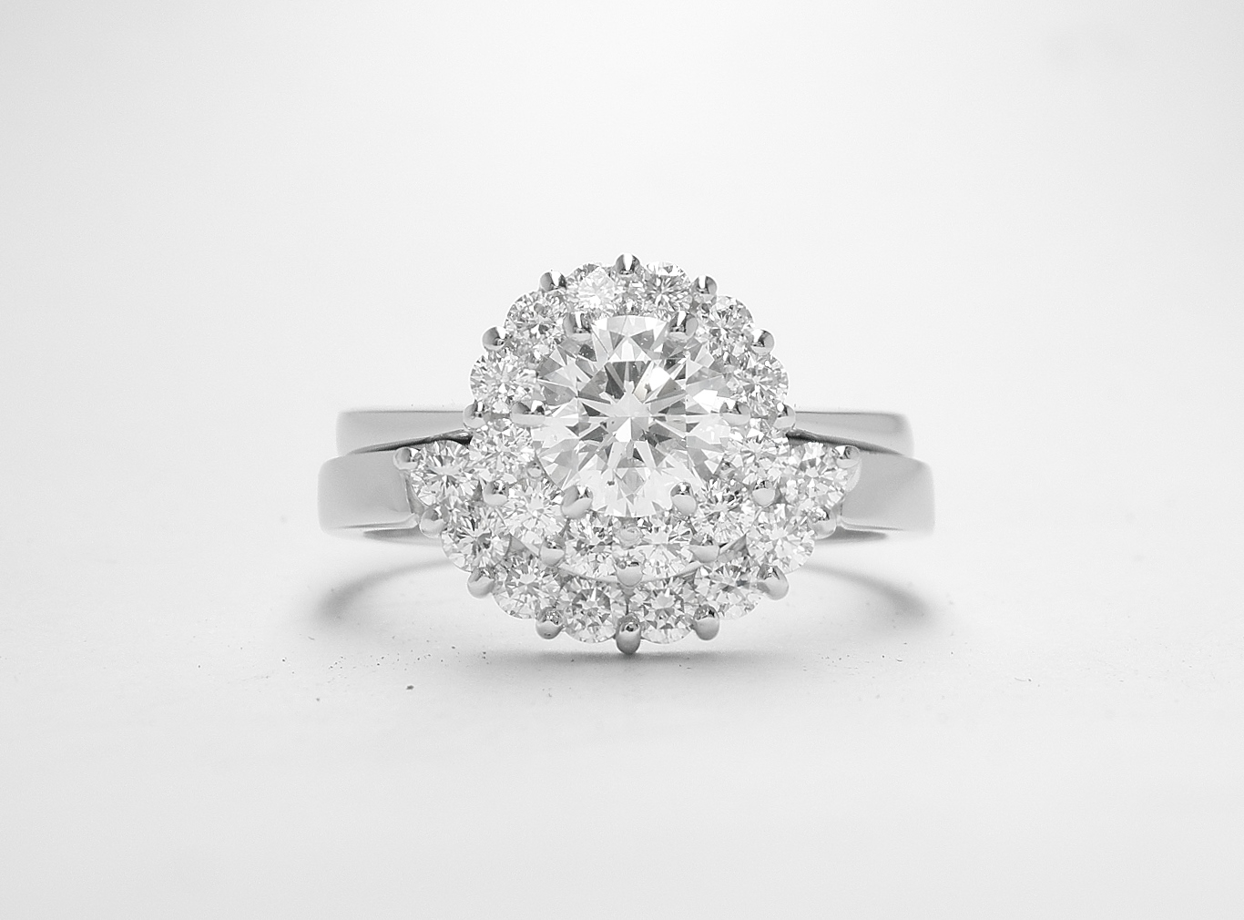 An 8 stone part channel set round brilliant cut diamond ring mounted in platinum and shaped to fir around a 13 stone round diamond cluster ring.