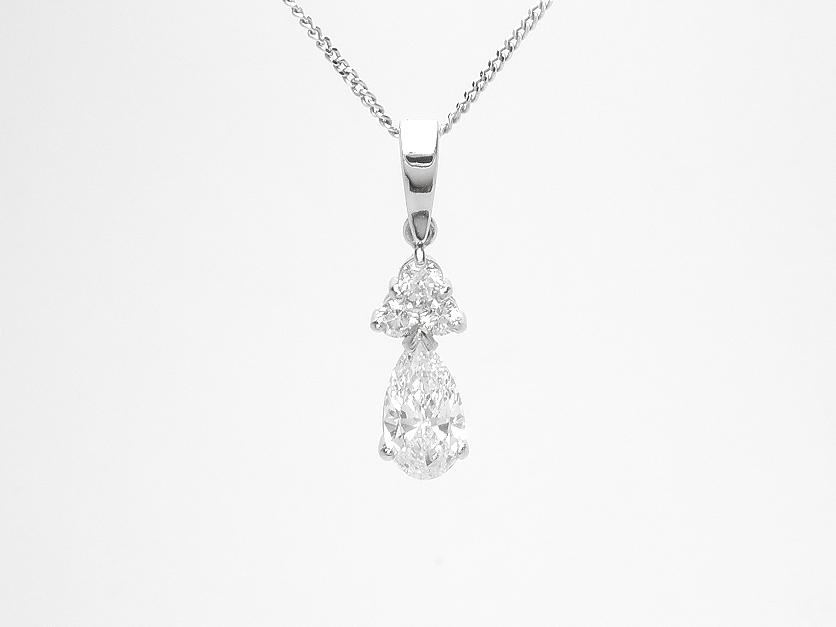 A 4 stone round brilliant cut and pear cut diamond pendant mounted in platinum