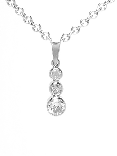 A 3 stone round brilliant cut diamond pendant mounted in platinum rub-over settings