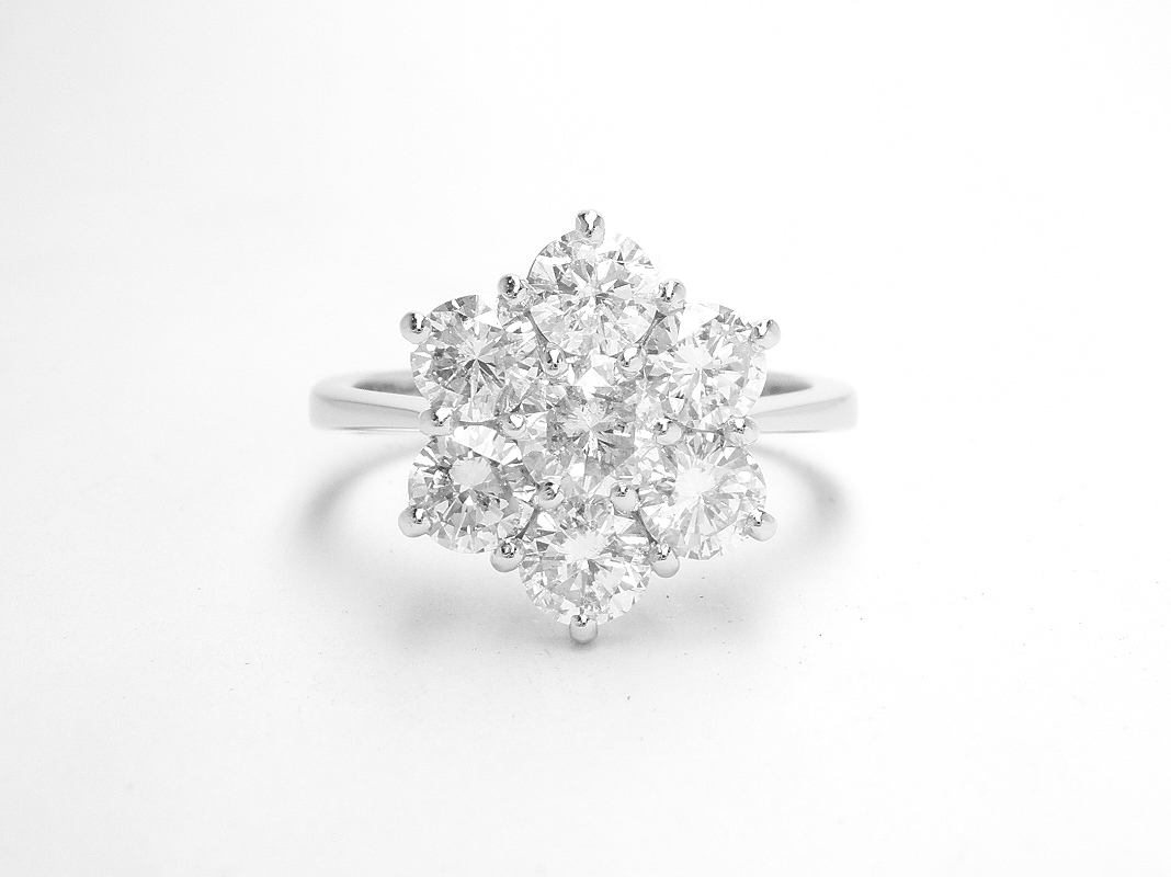 A 7 stone round brilliant cut diamond cluster set in platinum.