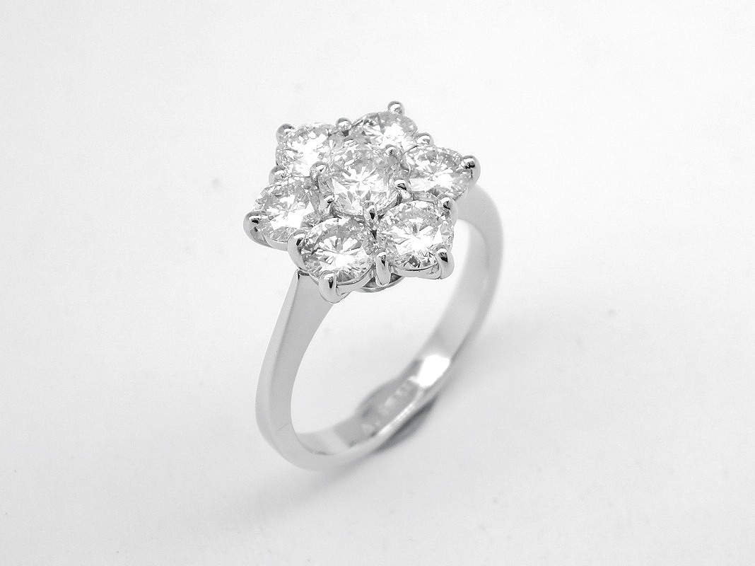 A 7 stone round brilliant cut diamond cluster set in platinum.
