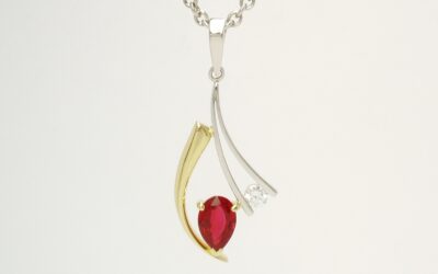 A 2 stone pear ruby and round brilliant cut diamond pendant mounted in 18ct. yellow gold and platinum.