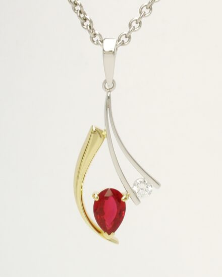 A 2 stone pear ruby and round brilliant cut diamond pendant mounted in 18ct. yellow gold and platinum.