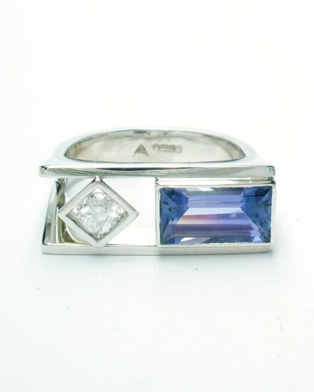 A 2 stone baguette cut Tanzanite and round brilliant cut diamond ring, mounted in platinum with a plateau top.