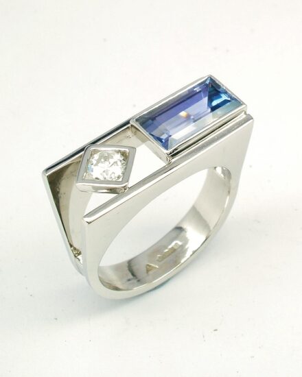 A 2 stone baguette cut Tanzanite and round brilliant cut diamond ring, mounted in platinum with a plateau top.