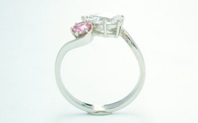 A 2 stone pear shaped Lab grown diamond and round pink sapphire cross-over style ring mounted in platinum.