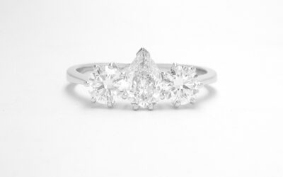 A 3 stone pear diamond and round brilliant cut diamond ring mounted in platinum.