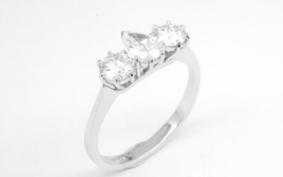 A 3 stone pear diamond and round brilliant cut diamond ring mounted in platinum.