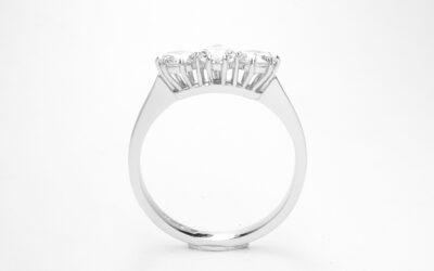 A 3 stone pear diamond and round brilliant cut diamond ring mounted in platinum.