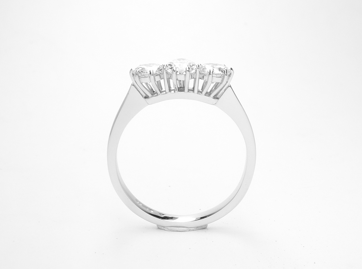 A 3 stone pear diamond and round brilliant cut diamond ring mounted in platinum.
