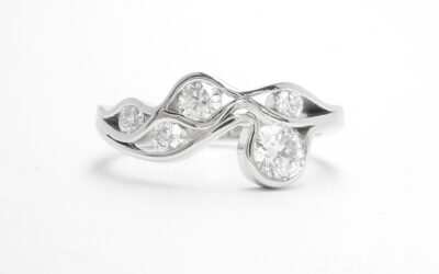 A 5 stone round brilliant cut diamond 'Wave' style ring mounted in platinum.