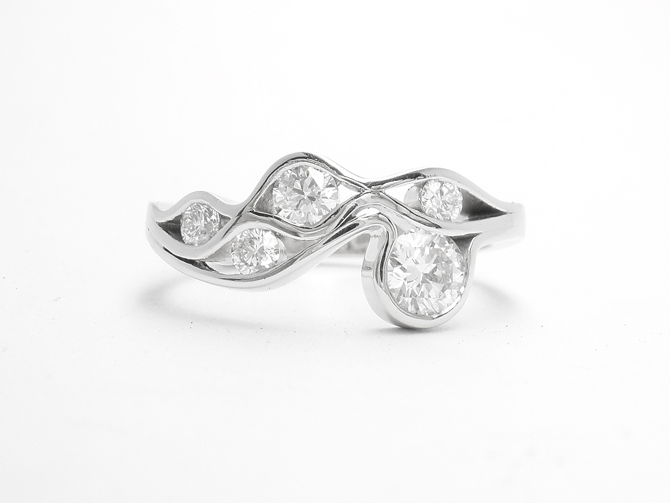 A 5 stone round brilliant cut diamond 'Wave' style ring mounted in platinum.