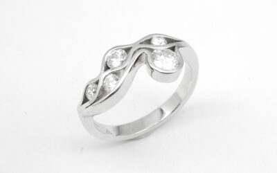 A 5 stone round brilliant cut diamond 'Wave' style ring mounted in platinum.