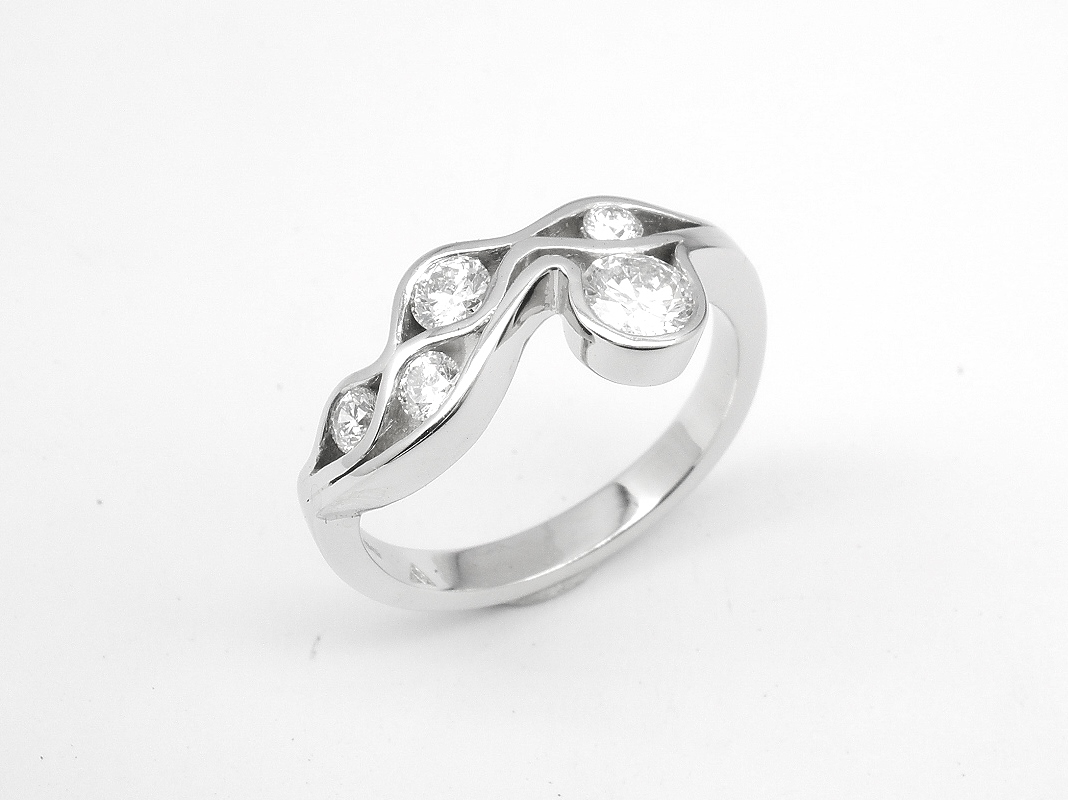A 5 stone round brilliant cut diamond 'Wave' style ring mounted in platinum.