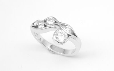 A 5 stone round brilliant cut diamond 'Wave' style ring mounted in platinum.