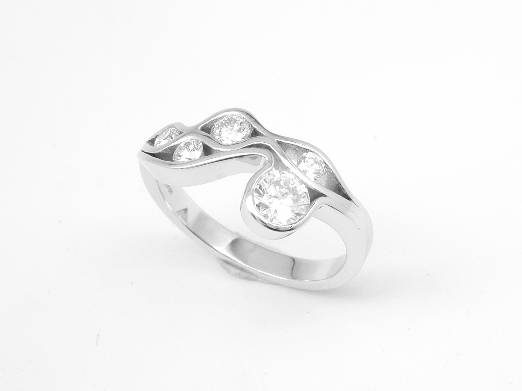 A 5 stone round brilliant cut diamond 'Wave' style ring mounted in platinum.