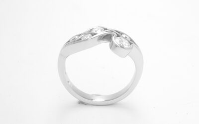A 5 stone round brilliant cut diamond 'Wave' style ring mounted in platinum.