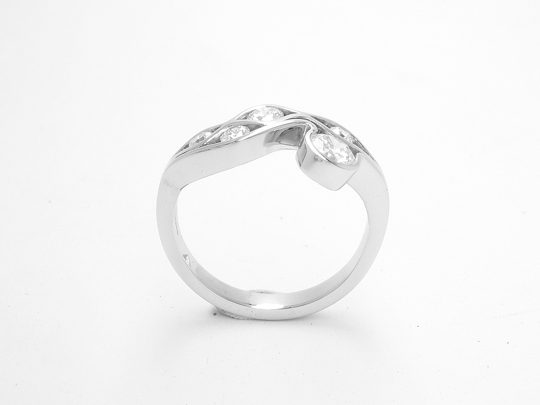 A 5 stone round brilliant cut diamond 'Wave' style ring mounted in platinum.