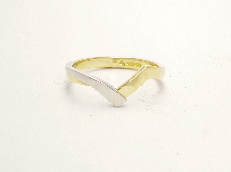 An 18ct. yellow gold and platinum shaped to fit around a 4 stone round brilliant cut diamond cross-over ring.