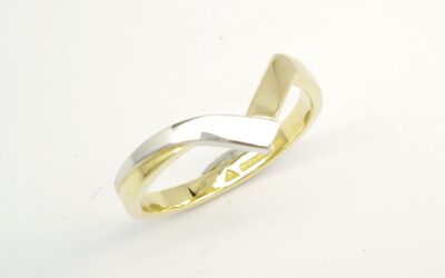 An 18ct. yellow gold and platinum shaped to fit around a 4 stone round brilliant cut diamond cross-over ring.