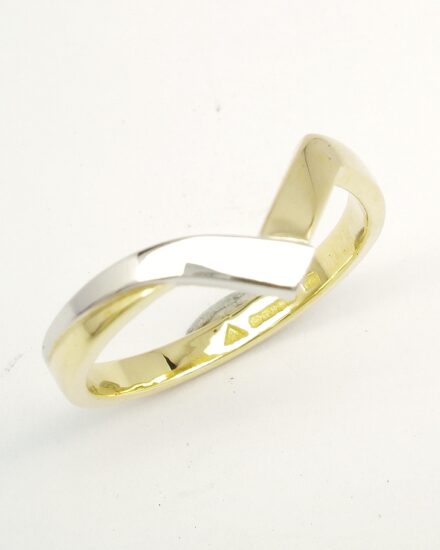 An 18ct. yellow gold and platinum shaped to fit around a 4 stone round brilliant cut diamond cross-over ring.