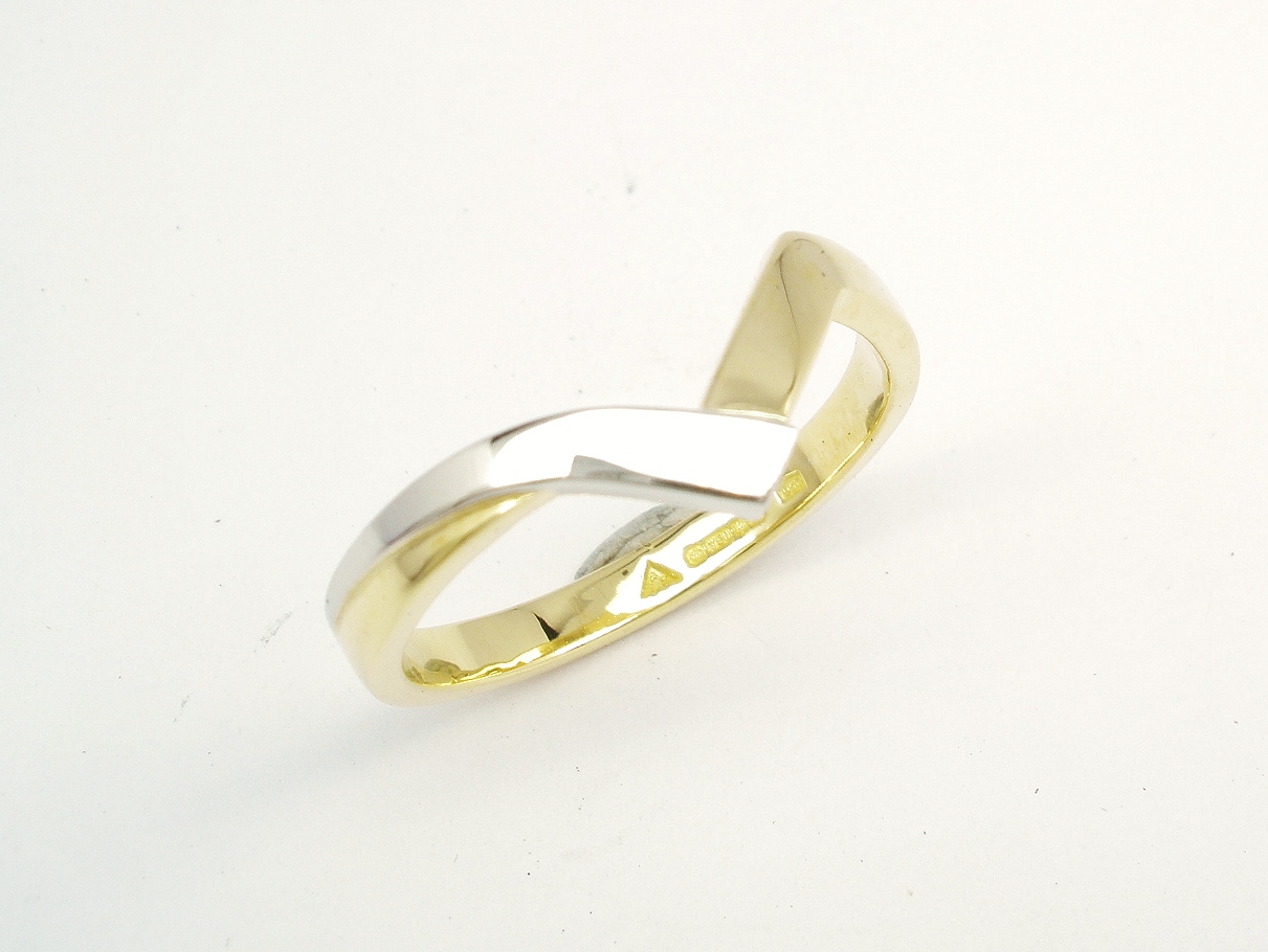 An 18ct. yellow gold and platinum shaped to fit around a 4 stone round brilliant cut diamond cross-over ring.