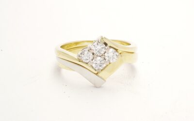 An 18ct. yellow gold and platinum shaped to fit around a 4 stone round brilliant cut diamond cross-over ring.