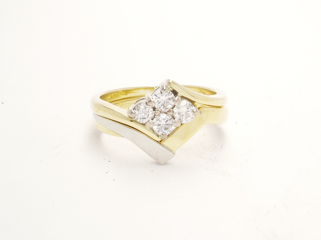 An 18ct. yellow gold and platinum shaped to fit around a 4 stone round brilliant cut diamond cross-over ring.