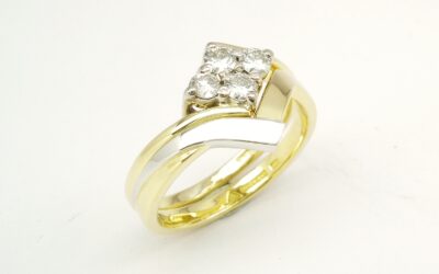 An 18ct. yellow gold and platinum shaped to fit around a 4 stone round brilliant cut diamond cross-over ring.